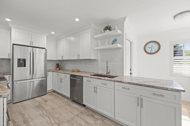 kitchen featuring appliances with stainless steel finishes, backsplash, sink, white cabinets, and ornamental molding