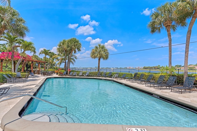 view of swimming pool with a patio area and a water view