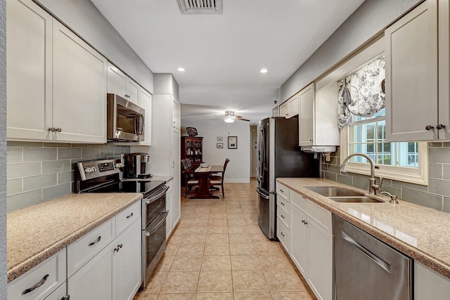 kitchen featuring stainless steel appliances, white cabinetry, ceiling fan, and sink