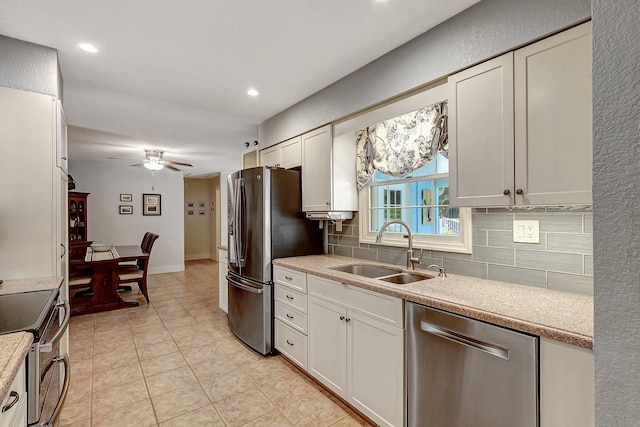 kitchen with white cabinets, appliances with stainless steel finishes, tasteful backsplash, and sink