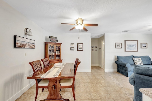 tiled dining room featuring ceiling fan and a textured ceiling