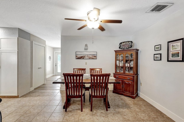 tiled dining room featuring ceiling fan and a textured ceiling