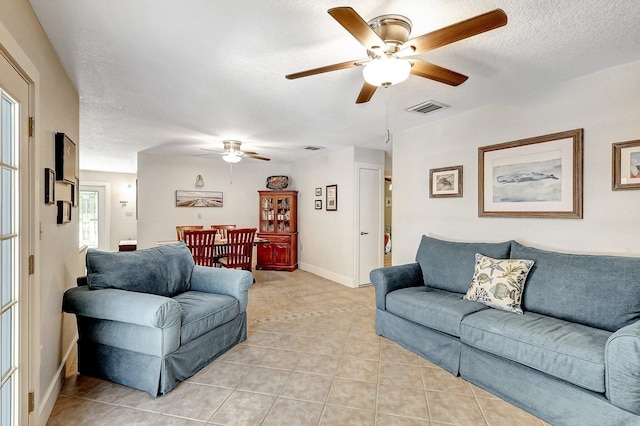 tiled living room featuring a textured ceiling and ceiling fan