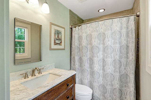 bathroom featuring vanity, toilet, and walk in shower