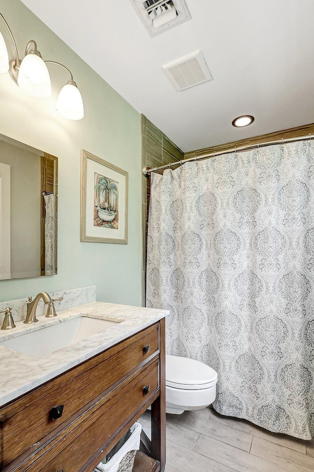 bathroom with hardwood / wood-style floors, vanity, and toilet