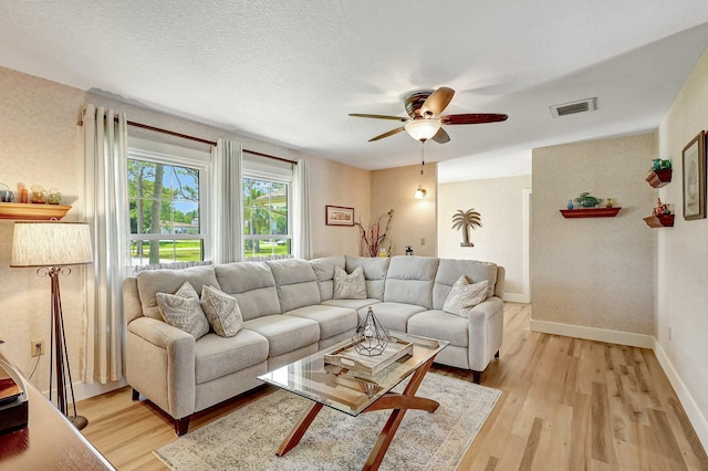 living room featuring ceiling fan and light hardwood / wood-style floors