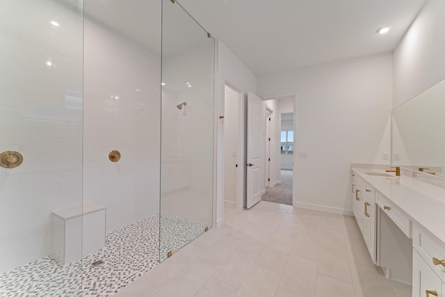 bathroom with vanity, tiled shower, and tile patterned floors