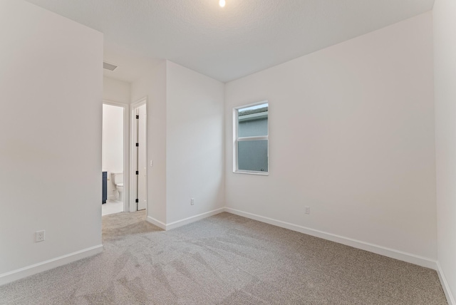 unfurnished room featuring light carpet