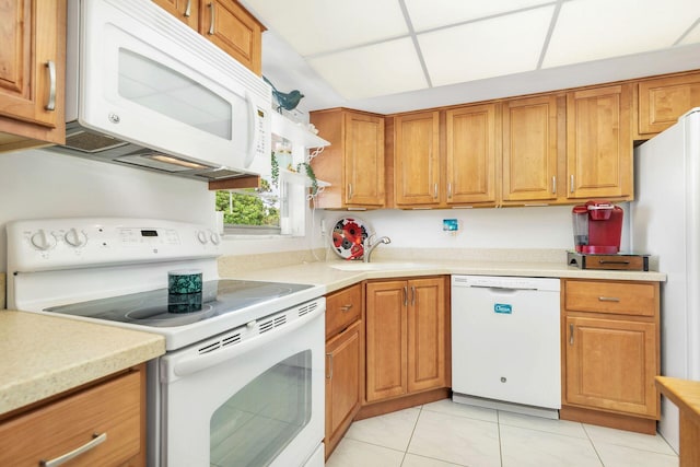 kitchen with sink, white appliances, and light tile floors