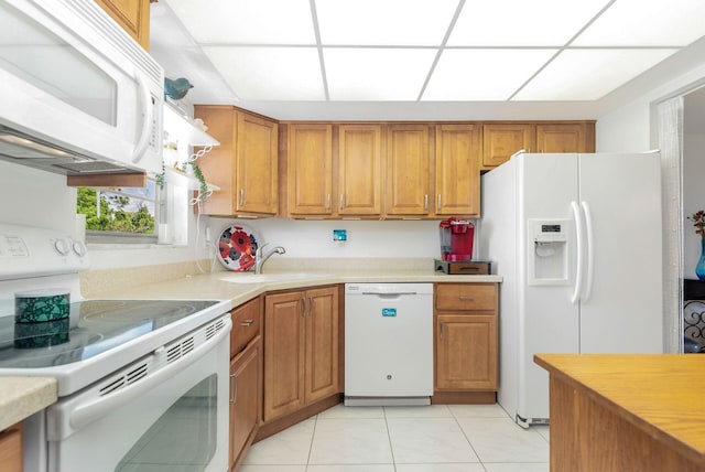 kitchen with white appliances, sink, and light tile floors