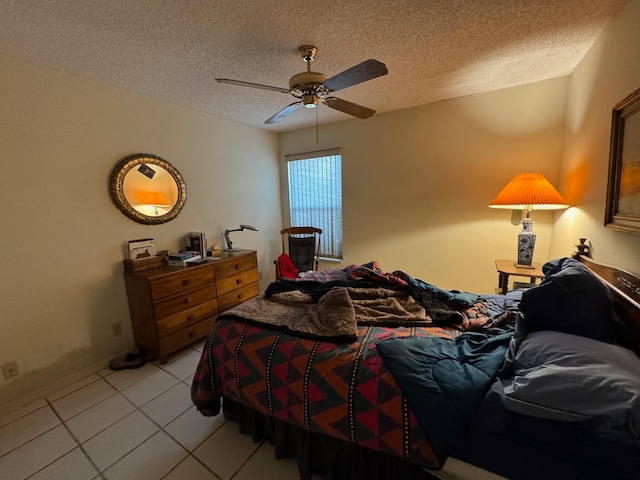 tiled bedroom with ceiling fan and a textured ceiling