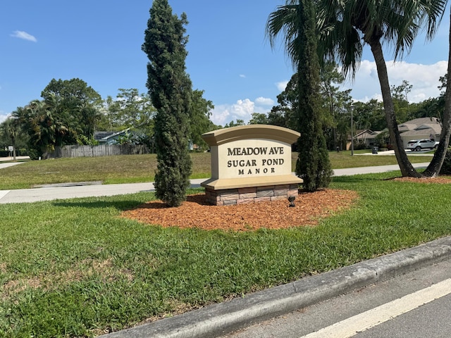 community / neighborhood sign with a yard