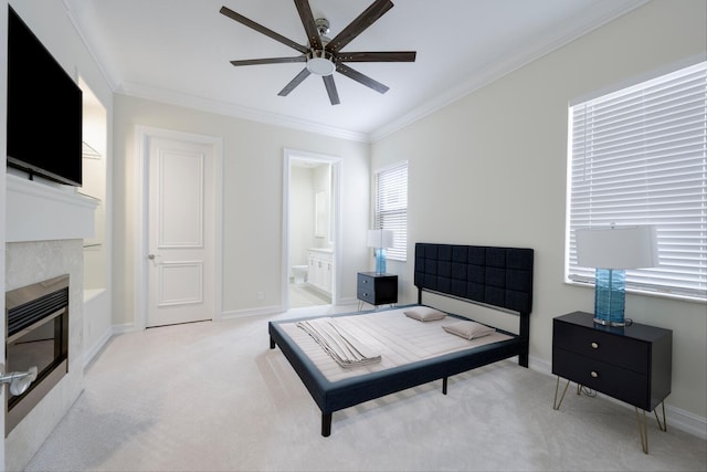 carpeted bedroom featuring a fireplace, connected bathroom, ceiling fan, and ornamental molding