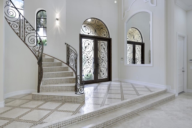 entryway with a towering ceiling and french doors