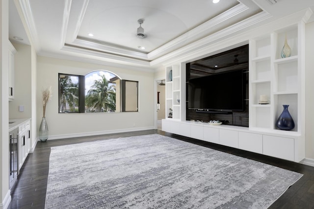 unfurnished living room with a raised ceiling, crown molding, dark hardwood / wood-style flooring, and ceiling fan