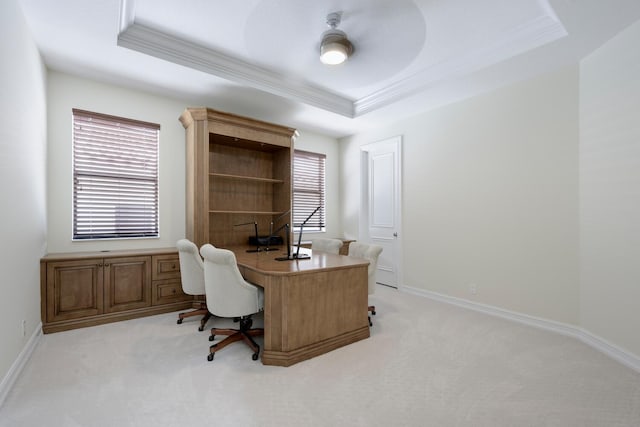 home office featuring a raised ceiling, plenty of natural light, and light colored carpet