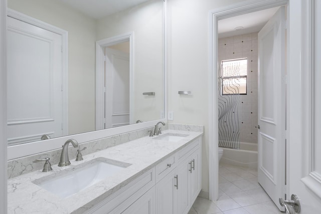 full bathroom with tile patterned flooring, tiled shower / bath combo, toilet, and vanity