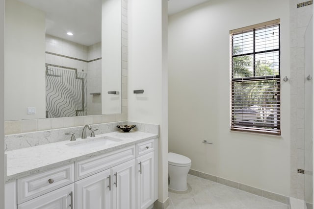 bathroom with tile patterned floors, vanity, a healthy amount of sunlight, and toilet