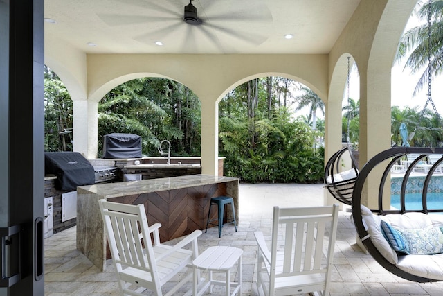 view of patio featuring outdoor lounge area, ceiling fan, grilling area, area for grilling, and a bar