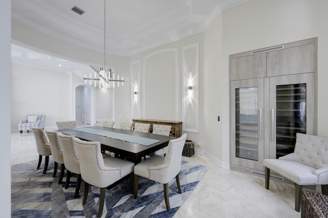 dining space with crown molding and a notable chandelier