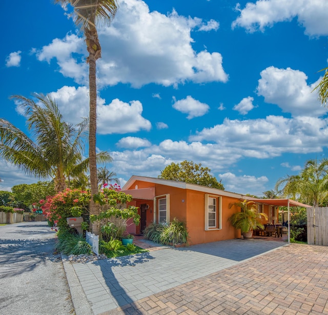 ranch-style home featuring fence and stucco siding