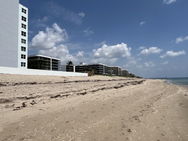 view of property's community featuring a beach view and a water view