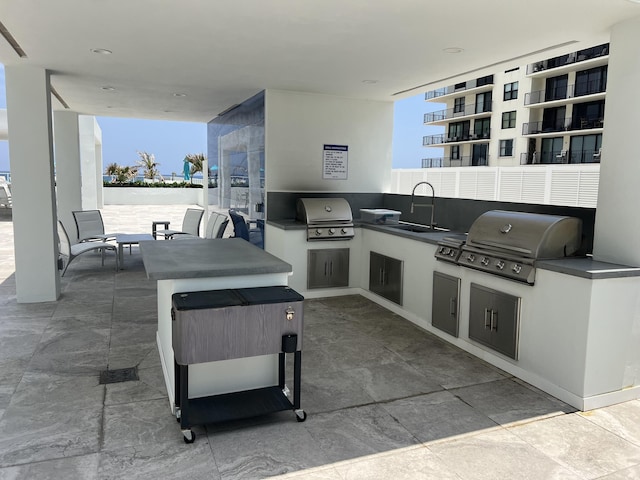 view of patio featuring exterior kitchen, grilling area, and a sink