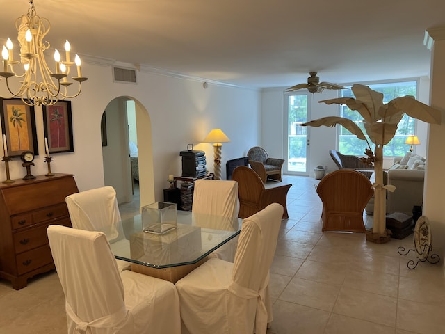 dining space with light tile patterned floors, visible vents, arched walkways, a ceiling fan, and ornamental molding