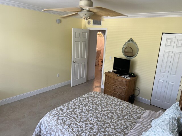 bedroom with crown molding, a closet, ceiling fan, and light tile patterned floors