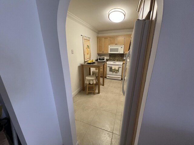 corridor featuring crown molding and light tile patterned floors