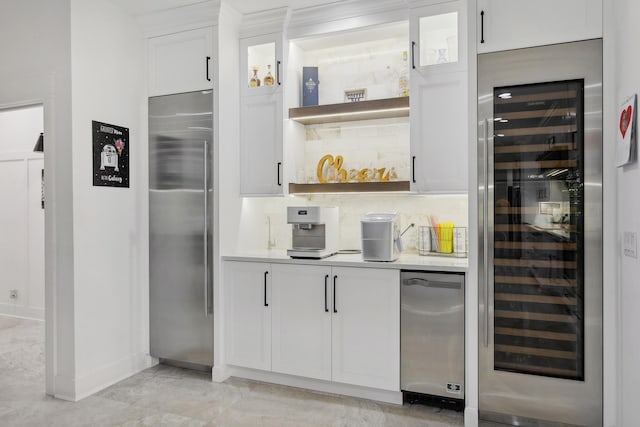 interior space featuring wine cooler, backsplash, white cabinets, and stainless steel built in refrigerator