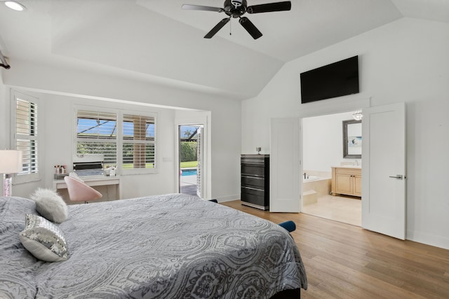 bedroom featuring vaulted ceiling, access to exterior, ceiling fan, ensuite bath, and light hardwood / wood-style flooring