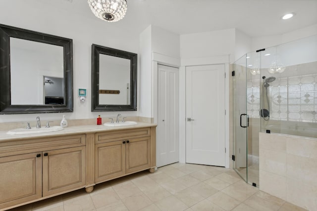 bathroom featuring a shower with door and vanity