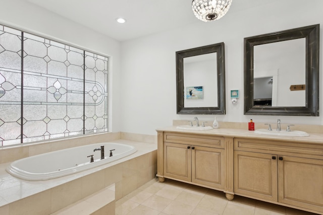 bathroom featuring vanity, tile patterned flooring, and tiled tub