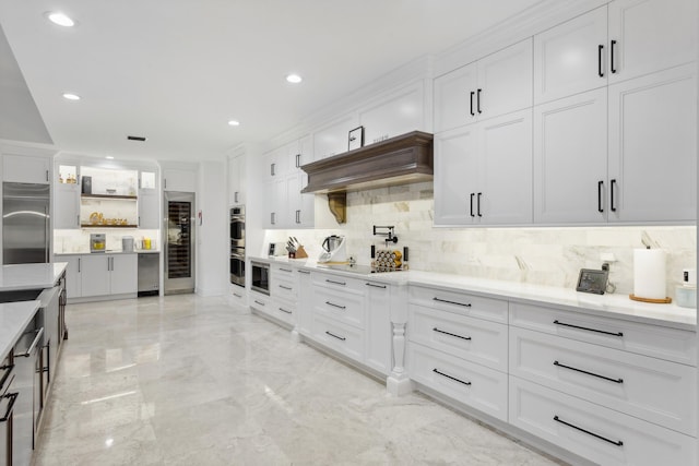 kitchen featuring white cabinetry, stainless steel appliances, light stone countertops, and tasteful backsplash