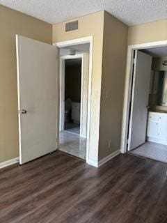 spare room featuring dark hardwood / wood-style flooring and a textured ceiling