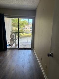 spare room with dark hardwood / wood-style flooring and a textured ceiling