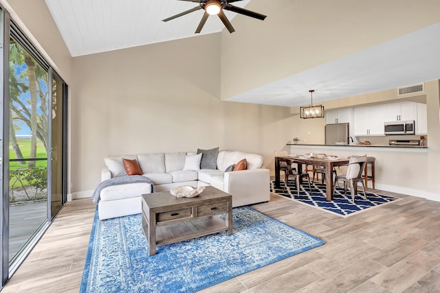 living room featuring ceiling fan with notable chandelier