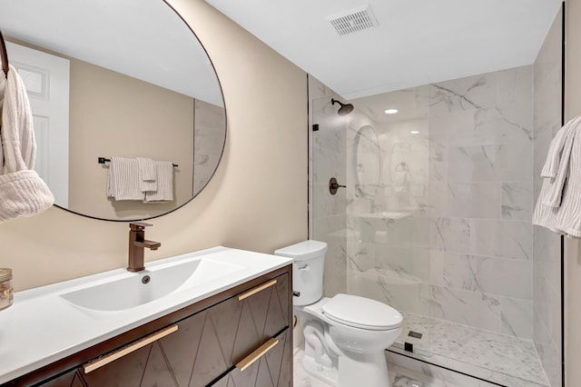 bathroom with vanity, toilet, and tiled shower