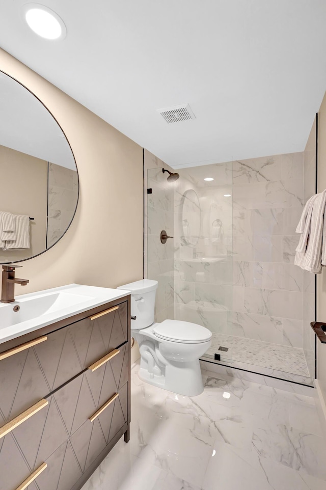 bathroom with tiled shower, vanity, and toilet