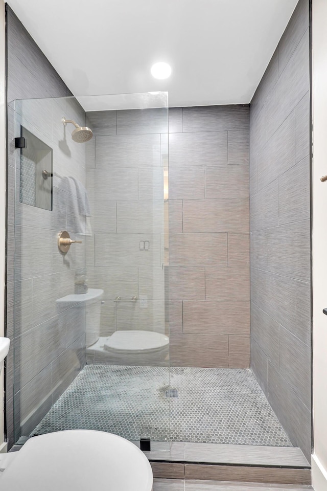 bathroom featuring toilet and tiled shower