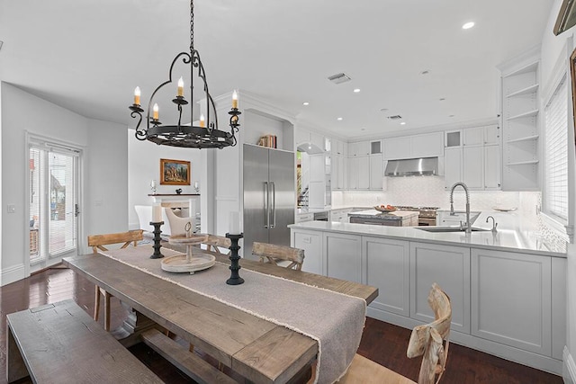 dining area with a notable chandelier, sink, and dark wood-type flooring