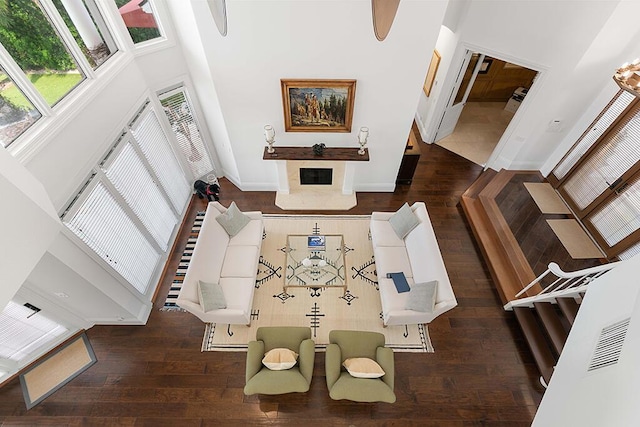 living room with dark wood-type flooring and a high ceiling