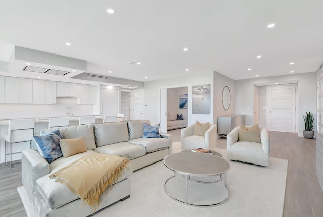 living room featuring sink and light hardwood / wood-style floors