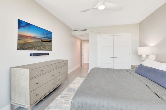 bedroom with ceiling fan, light hardwood / wood-style floors, and a closet