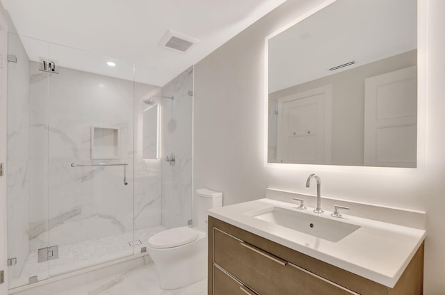 bathroom with vanity, toilet, and a shower with shower door