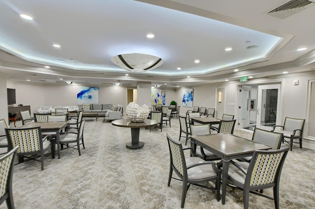 dining space featuring a tray ceiling and light colored carpet