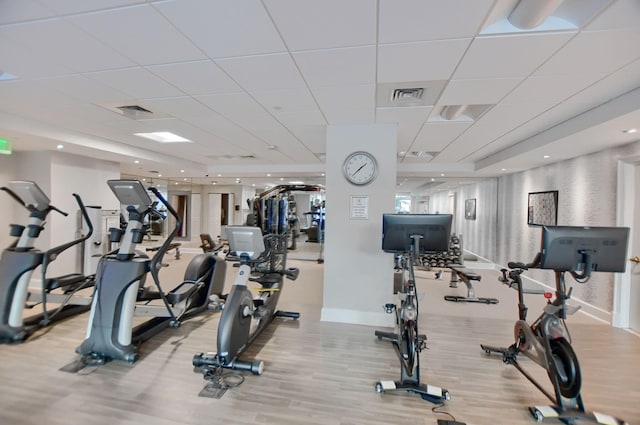 gym featuring a drop ceiling and light wood-type flooring