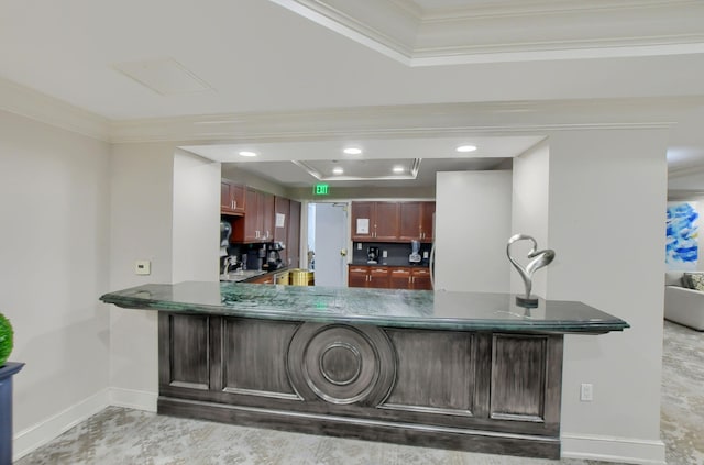 kitchen featuring crown molding, a tray ceiling, and kitchen peninsula