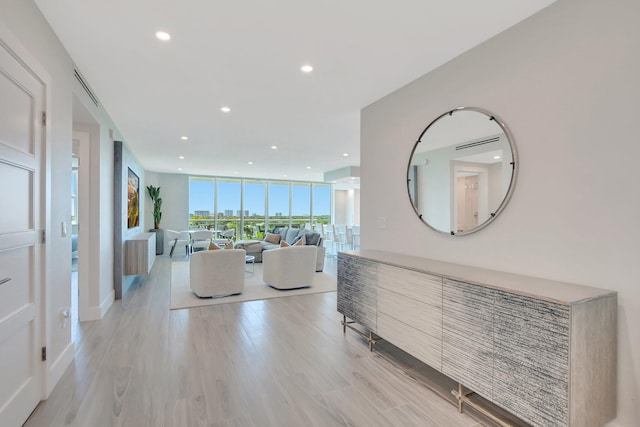 hallway featuring expansive windows and light hardwood / wood-style flooring